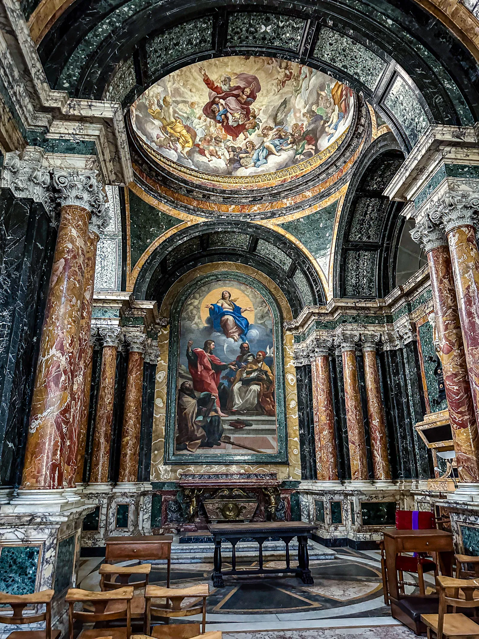 The intricate marble reliefs and ornate gold leaf ceiling of the Cybo Chapel