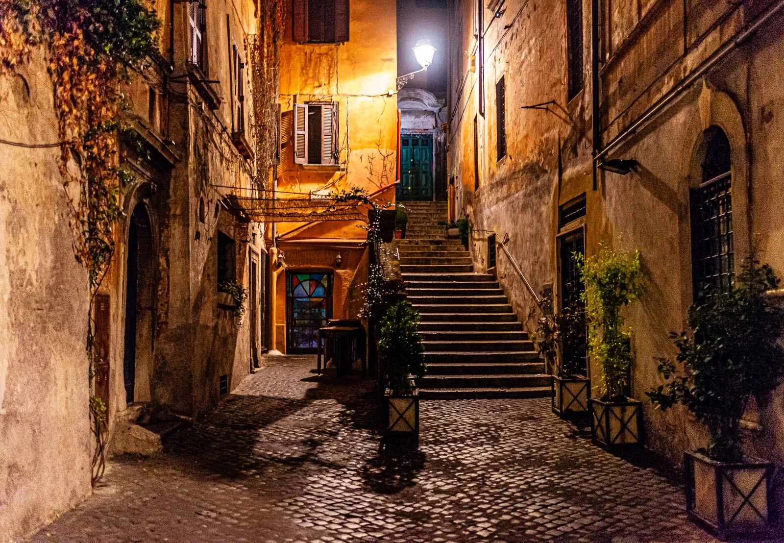 View of the neighborhood streets of Rome at night, with the illuminated lighting