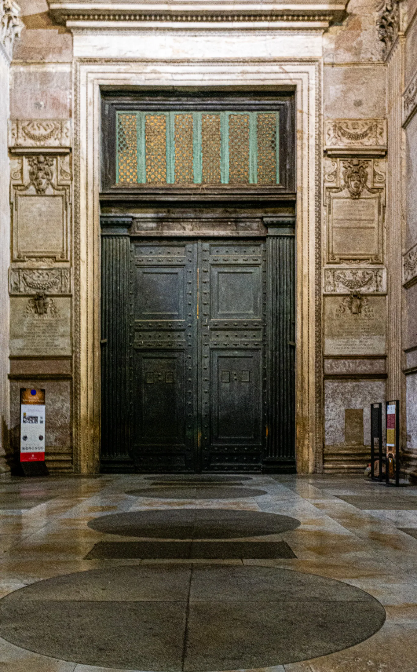 Pantheon doors at night, illuminated by warm lighting
