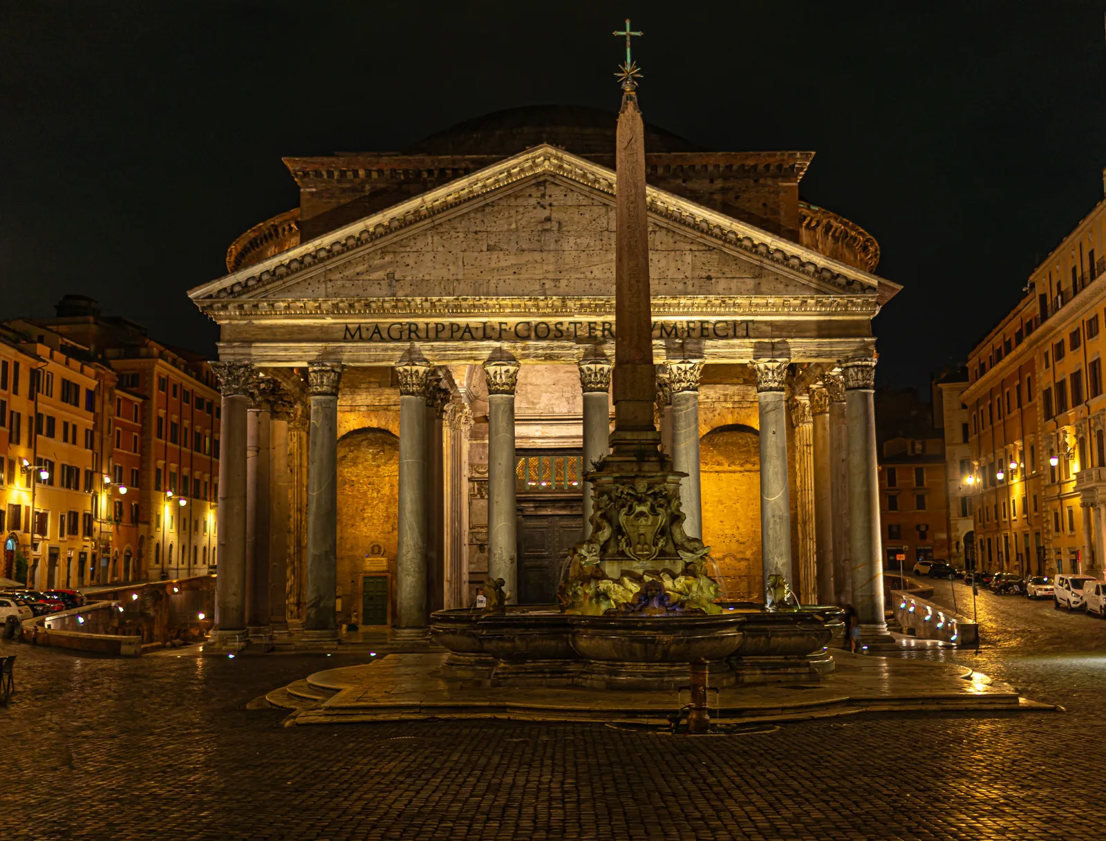 Exterior image of the Pantheon and fountain at night, illuminated by warm lighting